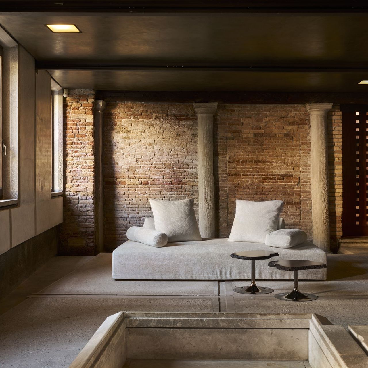  Sherazade and Cicladi. The sofa in sand-colored Gentle Cloud and the amber alabaster tables at the entrance to the Scarpa Area. 