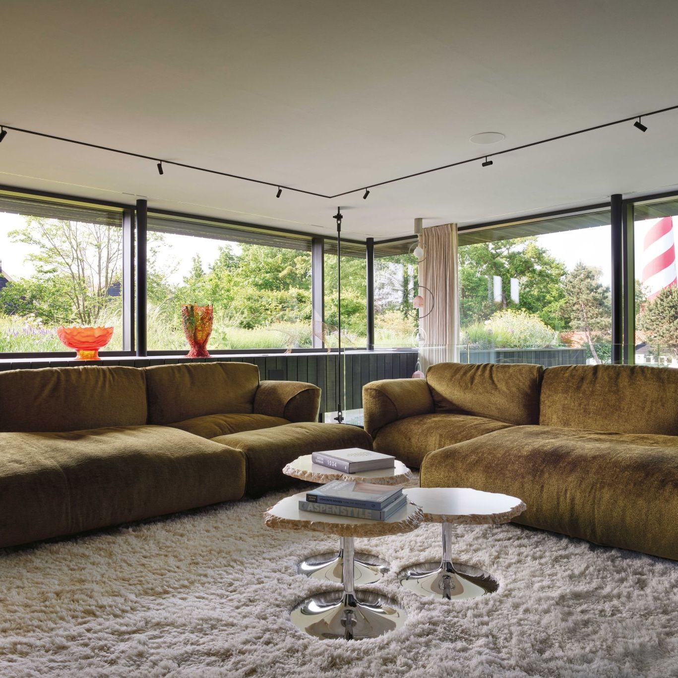   Grande Soffice  upholstered in a soft and welcoming moss green fabric in the TV room. In the foreground natural alabaster Cicladi tables, in the background &ldquo;Volpe&rdquo; by Benedetta Mori Ubaldini, and vases by Gaetano Pesce. 