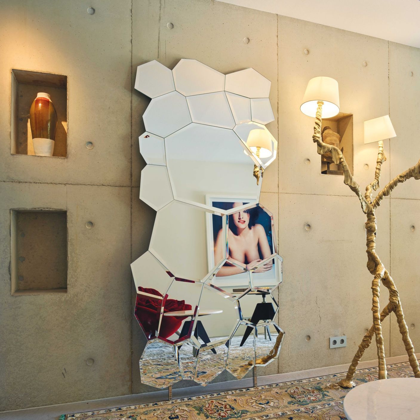   Jubil&eacute;. &nbsp;In a contrast with concrete the mirror&rsquo;s 25 shapes reflect light, artworks and furnishings. 