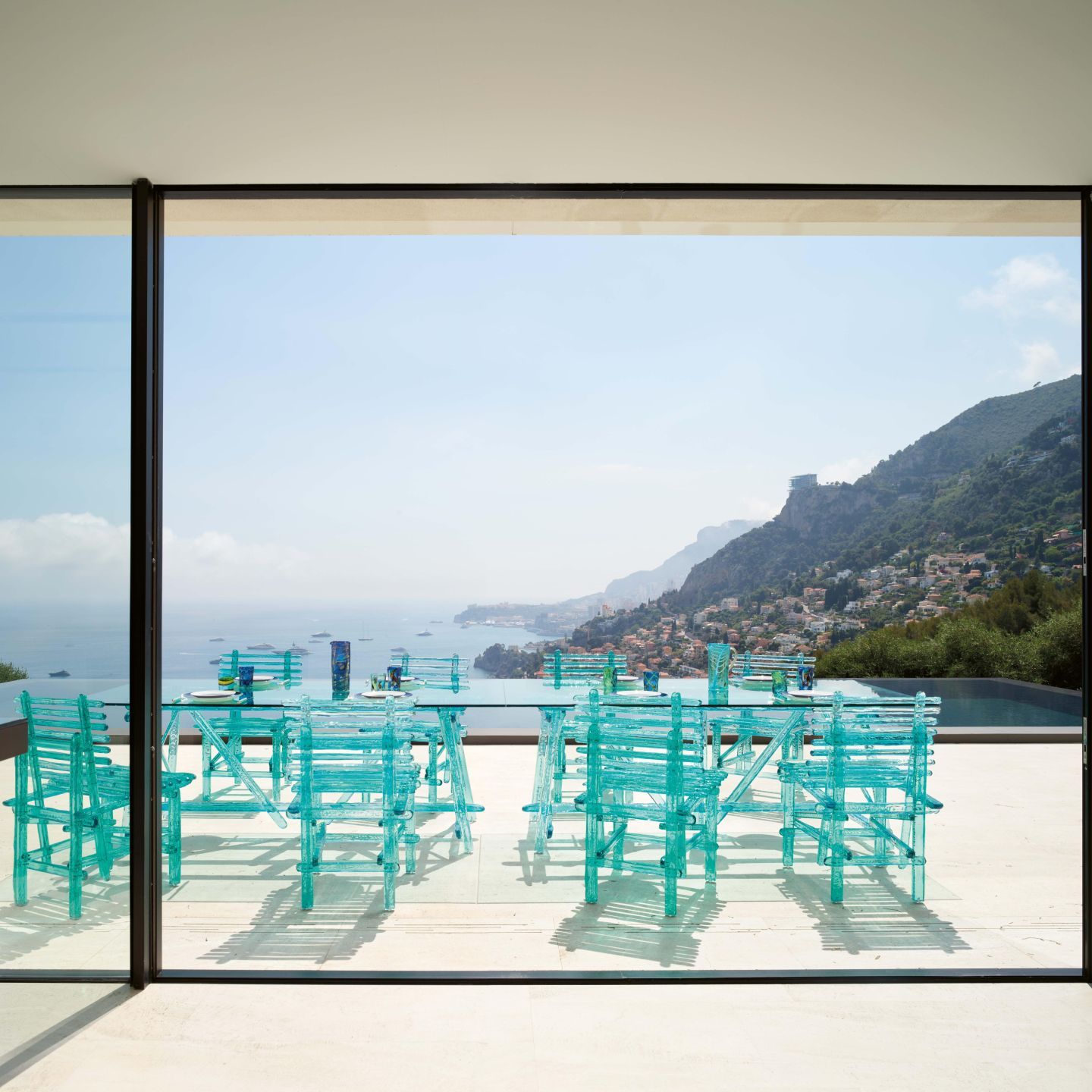  Les chaises et la table de la collection  A'mare  sur le solarium de la piscine &agrave; d&eacute;bordement. 