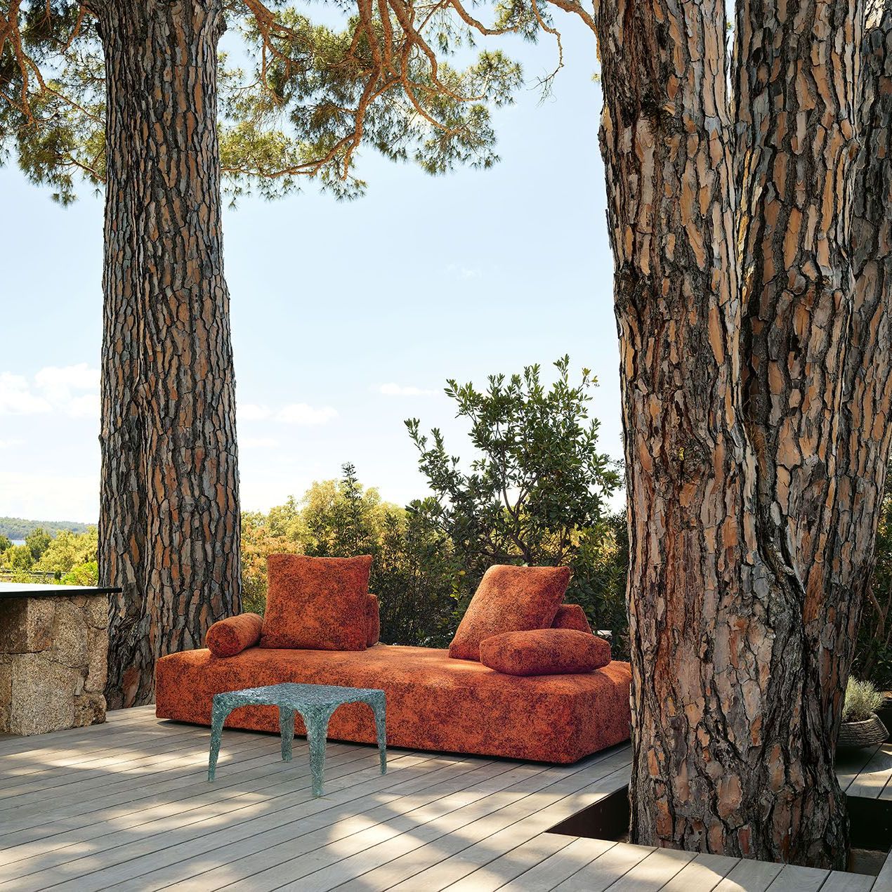  Sherazade Outdoor and Veronica. The sofa upholstered in Every Stone Imperial Red and the side tables open to the Pinarello landscape in a relaxing corner of the residence garden. 
